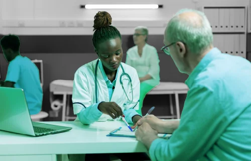 Clinician reviewing care plan details with a patient — representing the gap between care patients need and the care they receive
